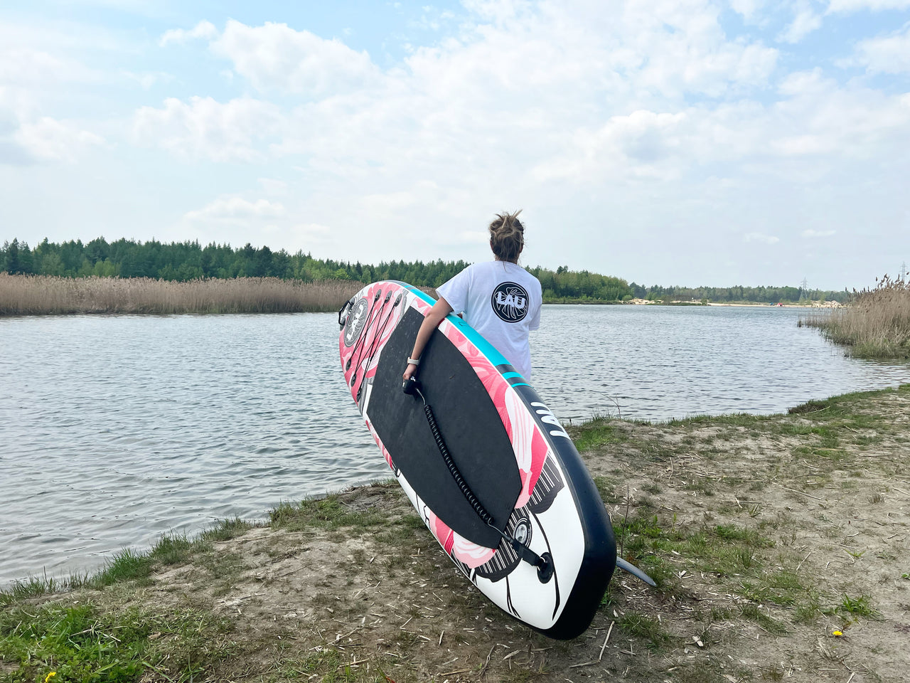 paddle board gonflable lau sup tenu devant une rivière du Québec