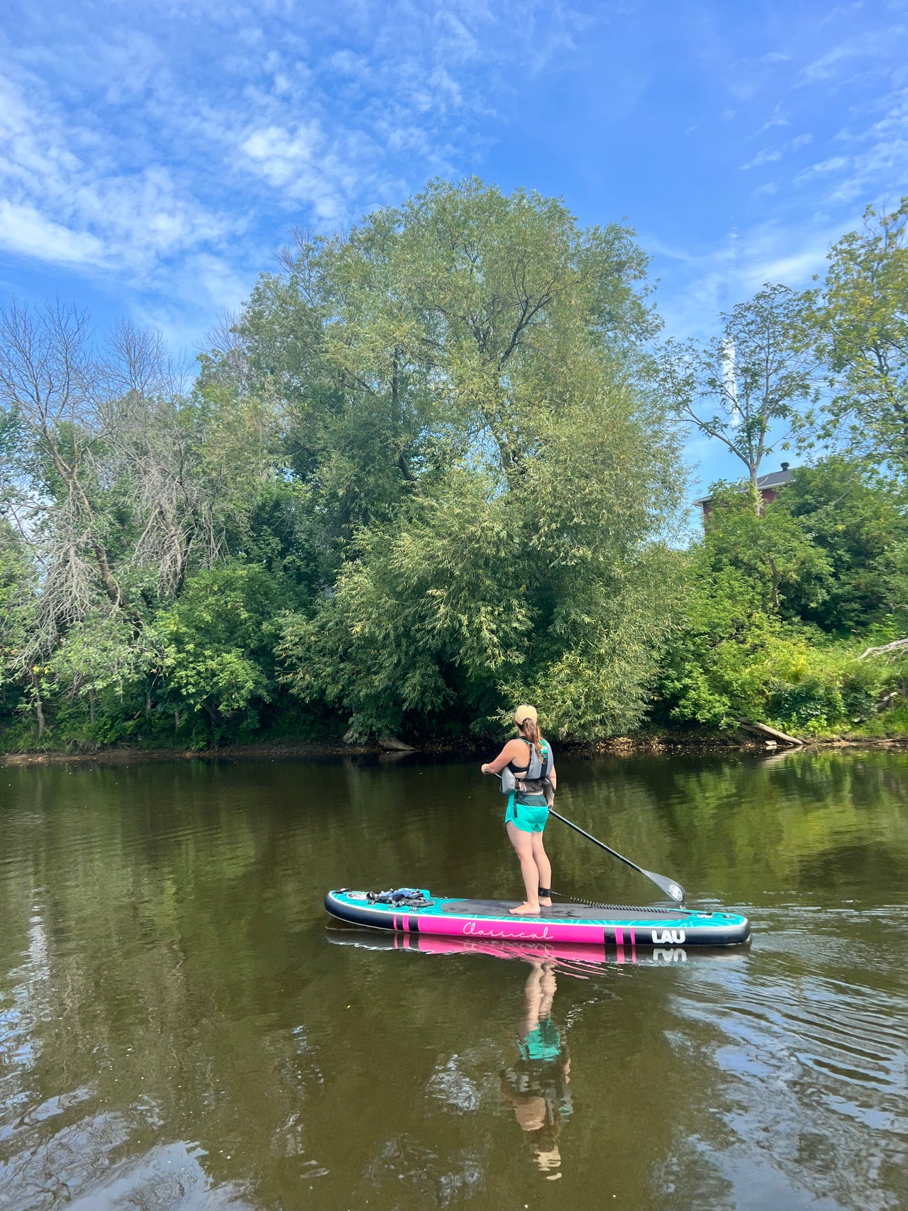 femme debout sur un paddle board gonflable lau sup sur une rivière au Québec